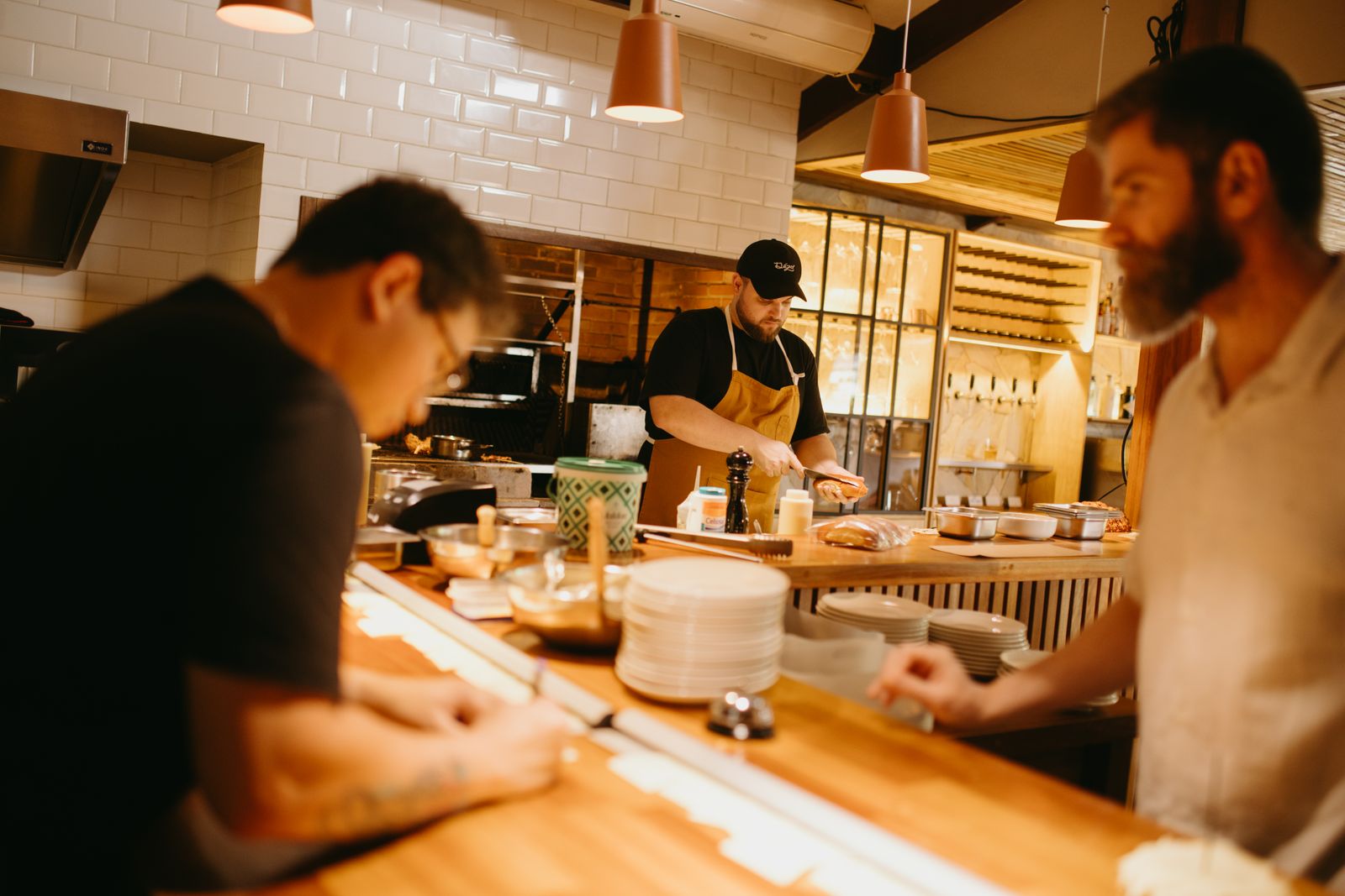 Profissionais preparando alimentos juntos na cozinha de um restaurante