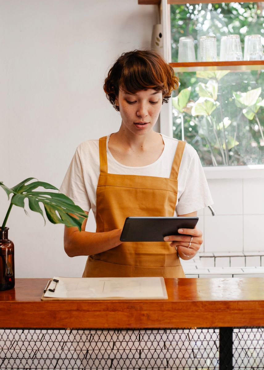 Profissional de um café usando um tablet no balcão